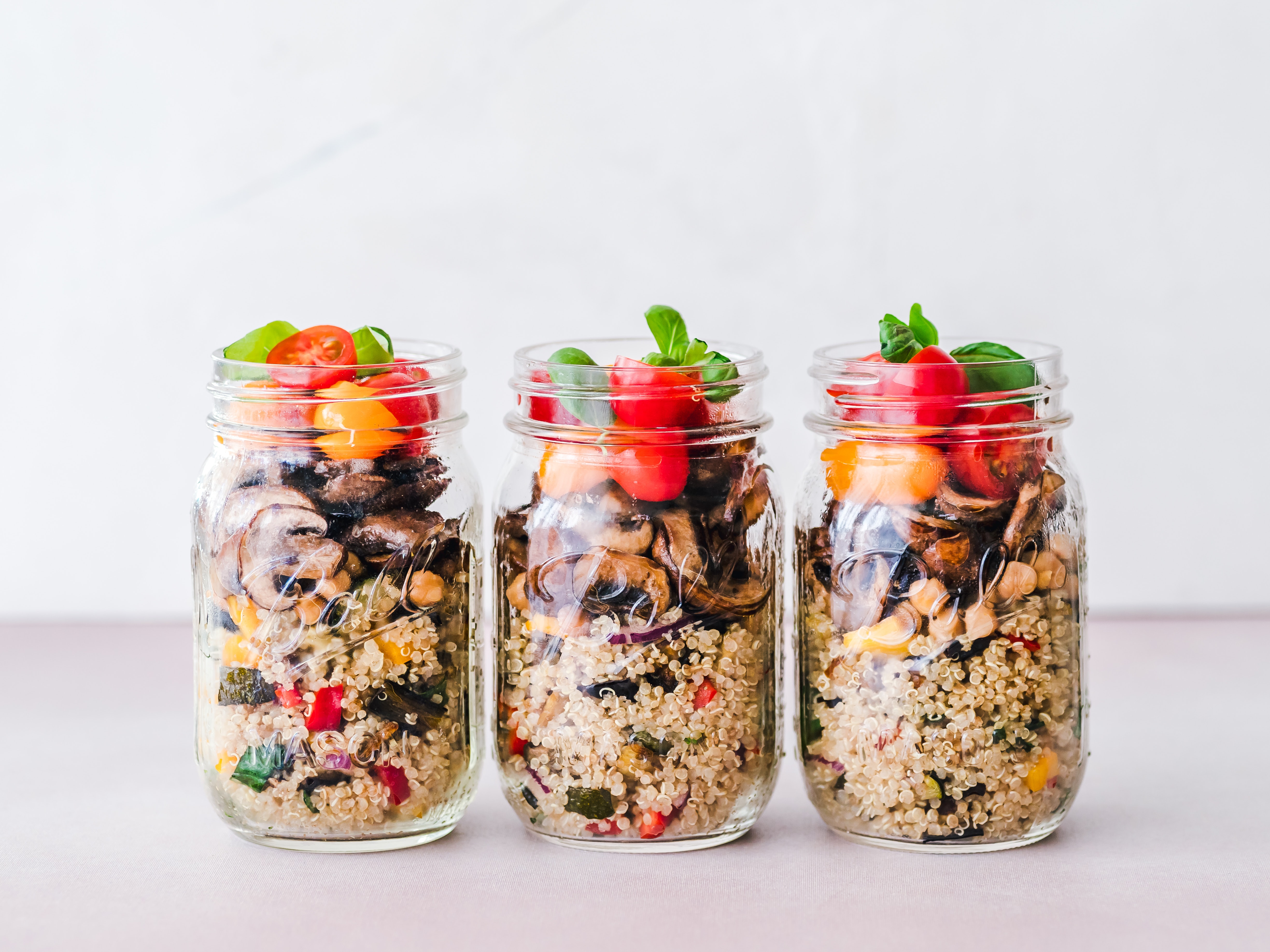 3 mason jars filled with quinoa salad
